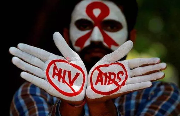A man with his hands painted Hiv and Aids crossed out.